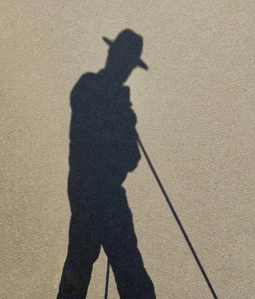Schatten auf goldenem Asphalt